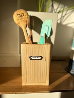 three wooden utensils in a holder on a table