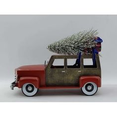 an old red truck with a christmas tree on top