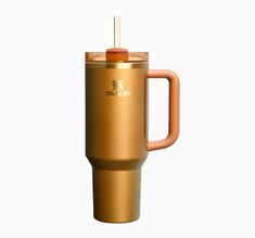 a gold travel mug with a straw sticking out of the top, on a white background