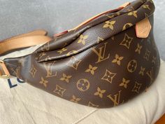 Overview Louis Vuitton Bum Bag in Canvas Monogram with gold hardware. Fashioned in classic Monogram canvas and signed with a “Louis Vuitton Paris” leather patch, this uber-functional bumbag transforms sportwear into the very definition of casual chic. Wear it as a belt bag, cross-body or over the shoulder for a jauntier look. This highly sought after style is no Longer available at LV and sells at premium usually. Features Monogram coated canvas Gold hardware Smooth cowhide leather trim Cotton c Luxury Brown Monogram Canvas Belt Bag, Louis Vuitton Mini Bumbag, Bumbag Louis Vuitton, Louis Vuitton Bumbag Thegearboxxshop, Louis Vuitton Empreinte Bumbag, Louis Vuitton Bumbag, Louis Vuitton Bum Bag, Louis Vuitton Paris, Classic Monogram