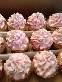 there are many cupcakes with pink frosting on them