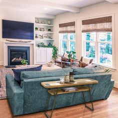 a living room filled with furniture and a flat screen tv mounted on the wall above a fireplace