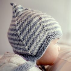 a close up of a baby wearing a knitted hat