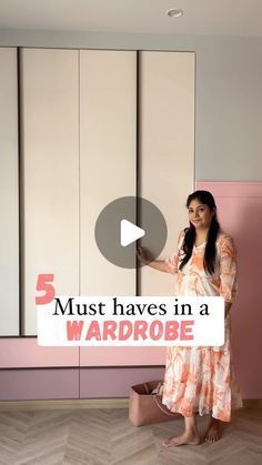 a woman standing in front of a pink wall holding a sign that says must haves in a wardrobe