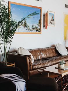 a living room filled with furniture and pictures on the wall above it's coffee table