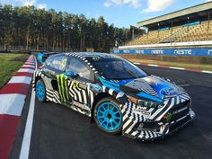 a racing car on a race track in front of an empty stadium bleachers