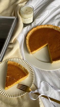 two slices of pumpkin pie on plates next to a book