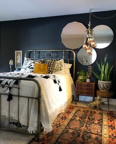 a bed room with a neatly made bed next to a rug and two hanging lights