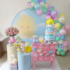 a birthday party with balloons and decorations on the wall, including a cake table and dresser