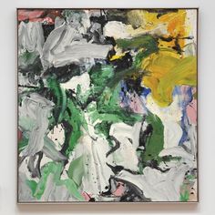 an abstract painting with green, yellow and white colors in a black frame on the wall