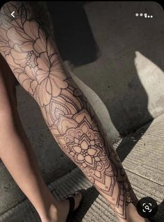 a woman's leg with flowers on it and her foot in the middle of the floor