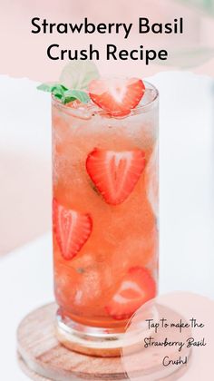 a strawberry basil crush recipe in a glass with ice and strawberries on the rim