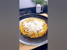 a pizza sitting on top of a pan covered in cheese and sauce next to a cup