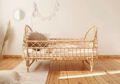 a wooden bed sitting on top of a hard wood floor next to a white wall