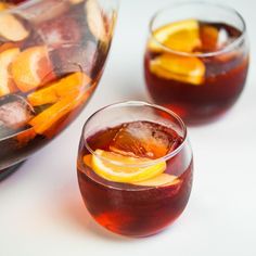 two glasses filled with red wine and orange slices