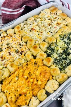 a casserole dish with spinach, cheese and other toppings in it