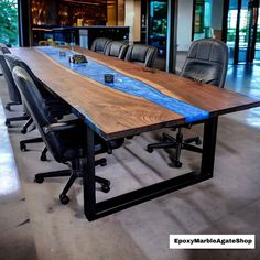 a conference table with chairs around it in an office building or conference room, made out of wood and metal