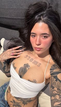 a woman with tattoos on her chest and arm