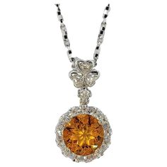 Introducing our exquisite 1.30 Carat Intense Golden Orange Citrine Diamond 18K White Gold Necklace Pendant, a captivating piece that radiates warmth and sophistication. At the heart of this pendant lies a round-cut intense golden orange citrine weighing 1.30 carats. This stunning gemstone is embraced by a halo of dazzling diamonds, enhancing its vibrant hue and adding a touch of sparkle to the design. The pendant's bail is elegantly adorned with a shamrock / three-leaf clover motif, featuring fo Orange Citrine, Three Leaf Clover, Pendant Bails, White Gold Necklaces, Diamond Pendant Necklace, Leaf Clover, Gold Pendant Necklace, Round Cut Diamond, Necklace Pendant