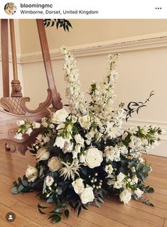 a bouquet of flowers sitting on top of a wooden floor next to an ornate mirror