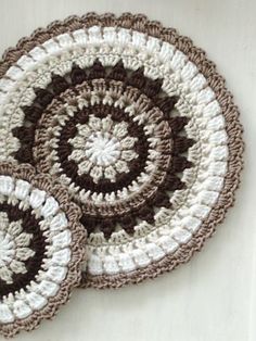 three crocheted coasters sitting on top of a table