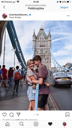 a man and woman are hugging in front of the tower bridge