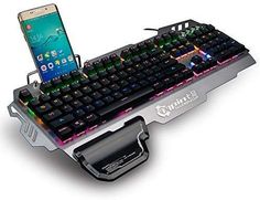 a cell phone is sitting on top of a computer keyboard that's attached to the side of it