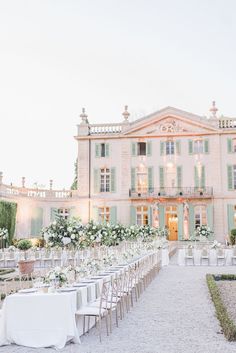 an outdoor wedding venue with tables and chairs set up in front of a large building