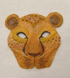 a wooden mask with a leopard's face painted on it