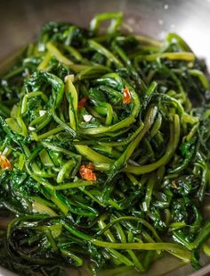 stir fried greens in a silver bowl on a table