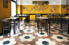 the interior of a restaurant with yellow walls and checkered flooring on the tables