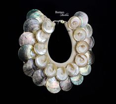 a wreath made out of seashells on a black background with the words bemo written above it