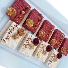 there are many different types of cakes on the trays with gold and red decorations