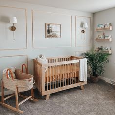 a baby's room with a crib, rocking chair and potted plant