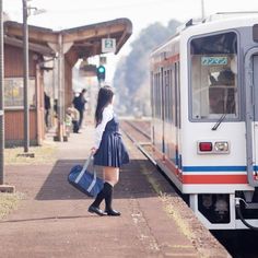 a woman is waiting for the train to arrive