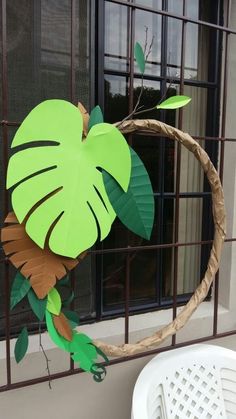 a paper cut out of a bird on top of a tree branch in front of a window