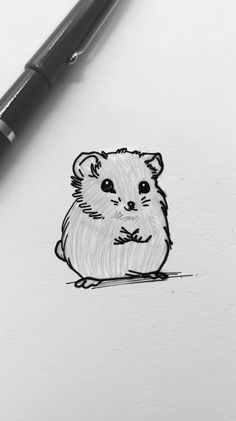 a drawing of a hamster on paper next to a pen