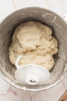 a metal bowl filled with dough on top of a counter