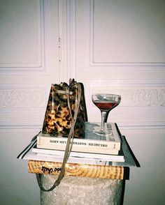 a stack of books and a wine glass on top of each other in front of a door