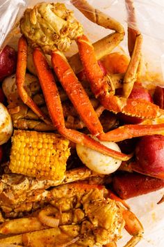 crab legs, corn on the cob and potatoes in a plastic bag with clear wrapper