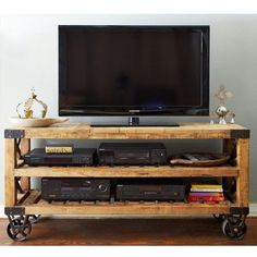 an entertainment center made out of wooden pallets and wheels with a flat screen tv on top