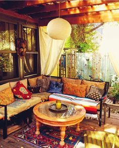 an outdoor living area with couches, tables and rugs