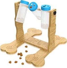 a wooden toy that has two bottles in it and some dog food on the ground