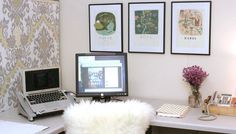 a laptop computer sitting on top of a desk next to a white fur covered chair