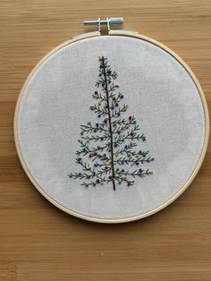 a small embroidered christmas tree on a wooden table