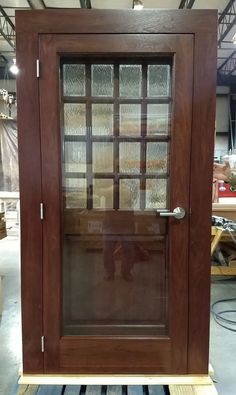 a wooden door with glass panels on the front and side doors, in a warehouse