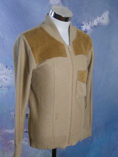 This 1970s camel tan wool-blend tight-knit jacket features golden brown corduroy on the upper front and on the one pocket on the front (left side). The jacket zips closed. Size: Small (36 US/UK) Material: 60% acrylic, 40% wool Chest = 38 inches (96.52cm)(This is a Size 36 US/UK; the extra 2 inches here allow for what you wear under and for ease of movement.) Shoulder Width = 17.5 inches (44.45cm) Sleeve Length = 24 inches (60.96cm) Jacket Length = 25 inches (63.5cm) Condition: Excellent (clean, Retro Beige Cardigan For Winter, Retro Beige Winter Cardigan, Fitted Brown Retro Cardigan, Fitted Vintage Beige Outerwear, Beige Fitted Retro Cardigan, Fitted Vintage Beige Cardigan, Vintage Brown Cardigan With Pockets, Long Overcoat, Brown Tweed