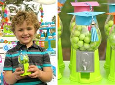 a boy holding a green apple in front of a machine filled with balls and tassels