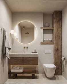 a bathroom with a toilet, sink and mirror