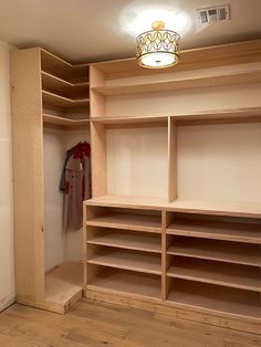 an empty walk in closet with wooden shelves